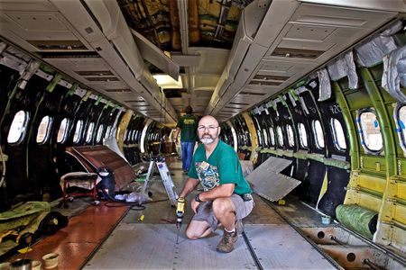 A maintenance worker inside a USAir commercial airplane installing the floor. Worker inside an Airplane