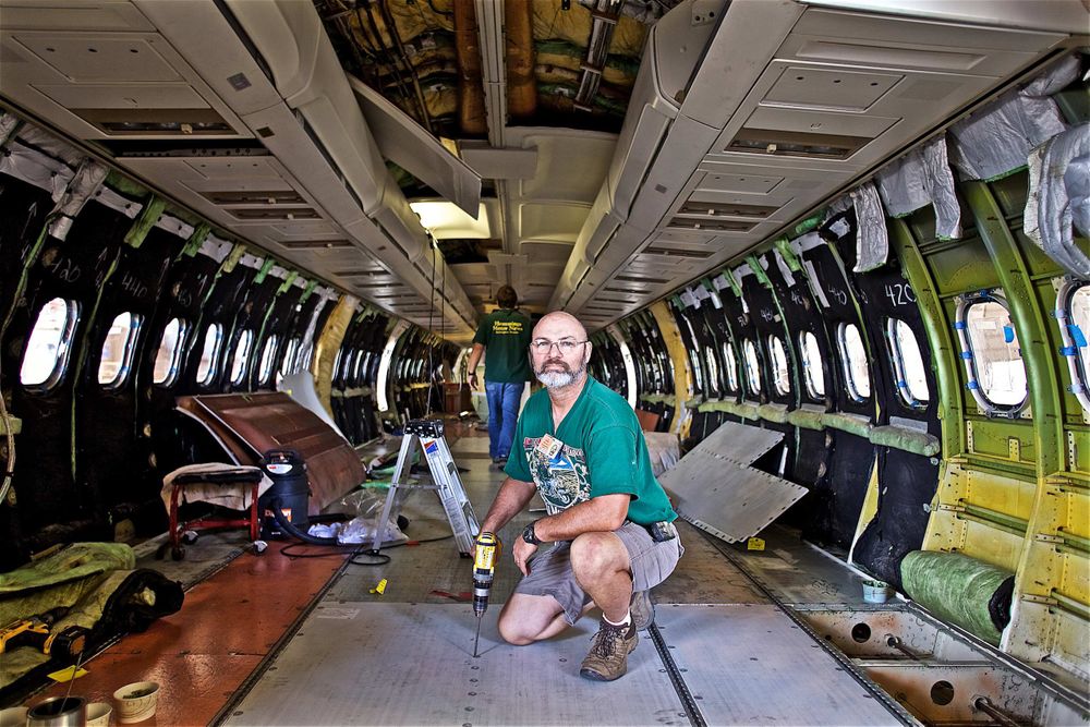 A maintenance worker inside a USAir commercial airplane installing the floor. Worker inside an Airplane