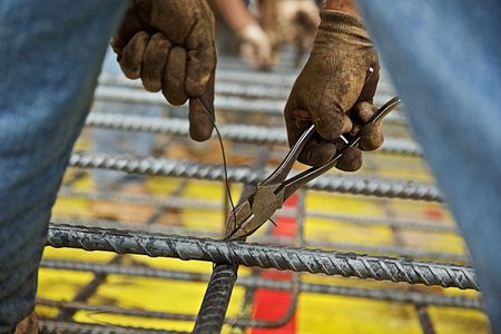 A man from a local union installing rebar to the floor of SolarCity, a large solar manufacturing facility in Buffalo, NY. Man Installing Rebar