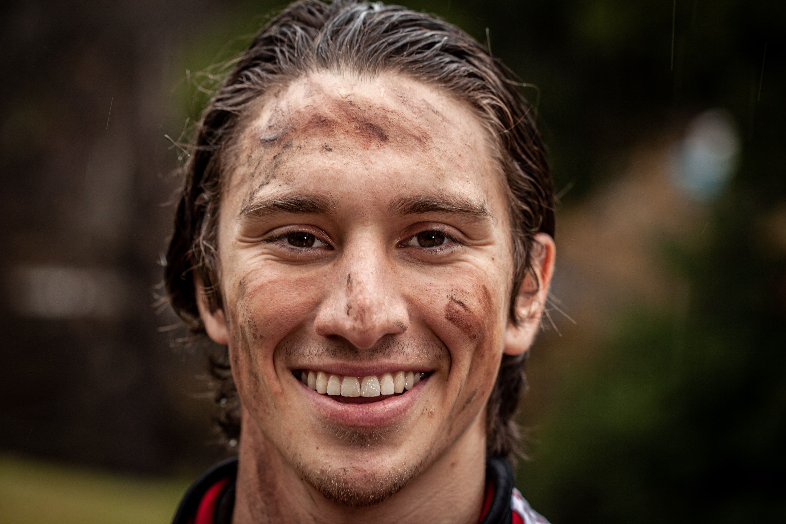 Man Smiling with Mud on Face