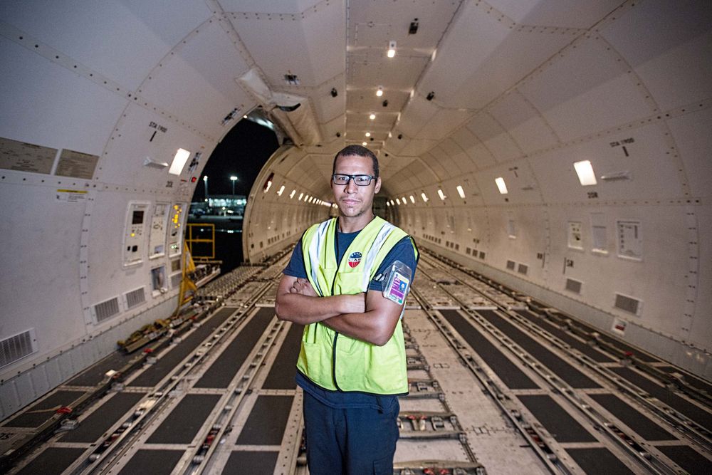 Graphic environmental portrait of a worker, wearing protective vests, standing in the interior of a Boeing 747-8 Freighter airplane. He is looking into the camera with a confident expression. Next stop, the other side of the world! This was a project shooting for the air cargo transportation industry. This project was amazing as an industrial photographer, on location photographer & location commercial photographer.
Shallow depth of field and selective focus that highlights the depth and area of the aircraft. Worker Standing inside an Empty Boeing 747 Cargo Plane