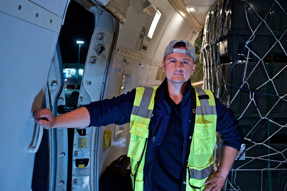 Interior photo of a Boeing 747-8 Freighter airplane of a male Load Master with the left side cargo door open, at night time. Next stop, the other side of the world! A project shooting for the air cargo transportation industry. This project was amazing as an industrial photographer, on location photographer & location commercial photographer.
Shallow depth of field and selective focus. Environmental portraits Load Master of a 747 Cargo Transportation Plane