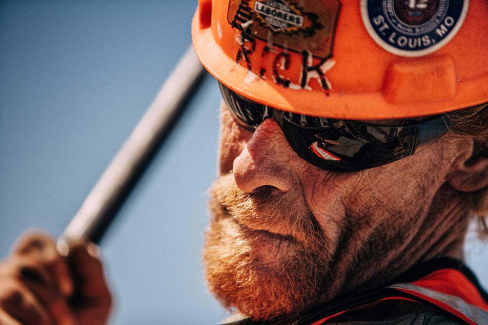 Closeup of a man with a tool, wearing safety hat, glasses, vest etc. Selective focus, shallow depth of field. Closeup of a Man With a Tool