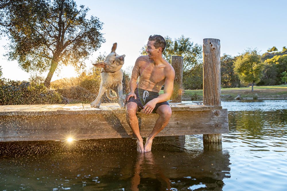 A Man and His Dog Sitting on a Pier