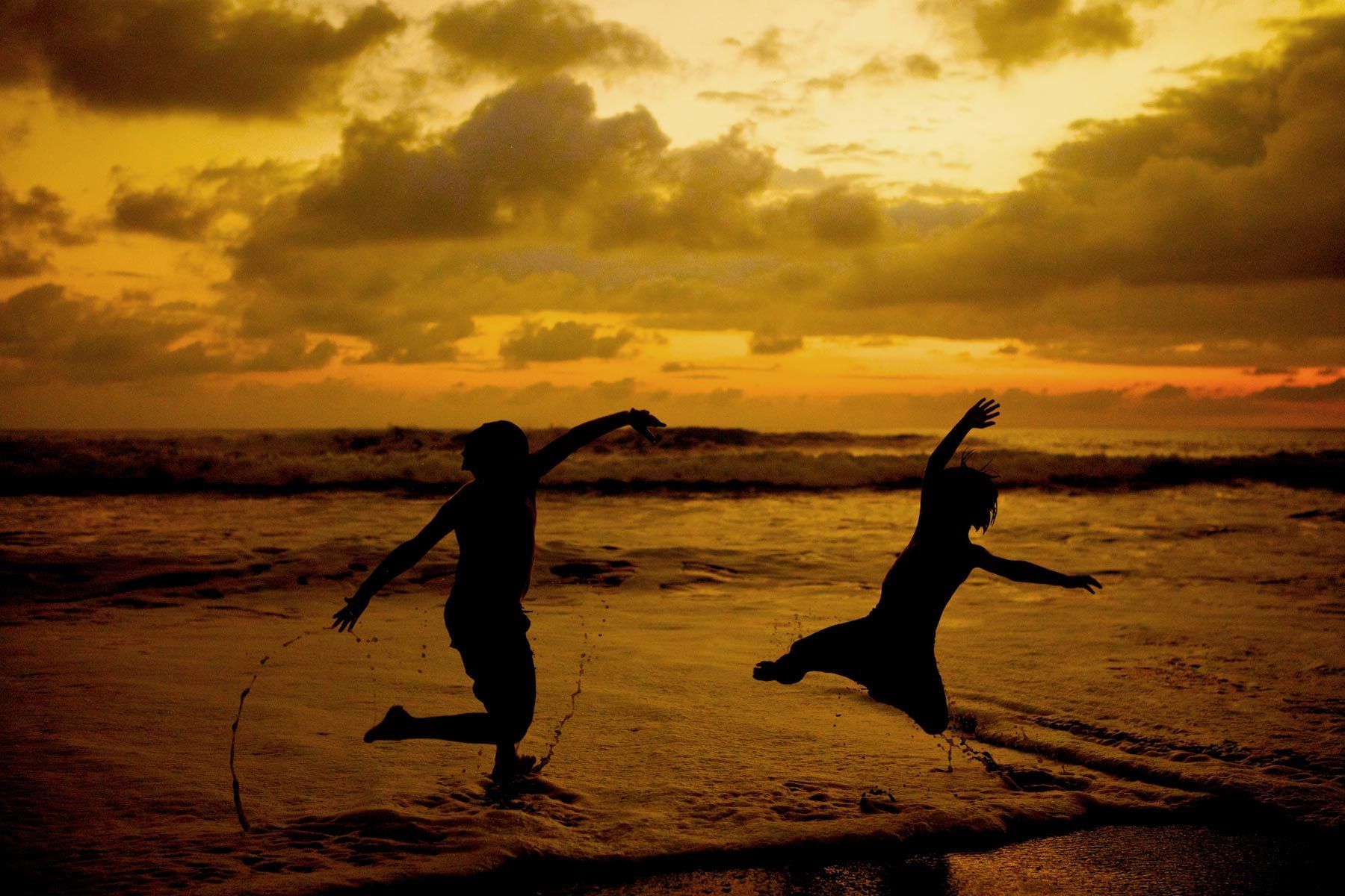 Boys Jumping on Beach at Sunset