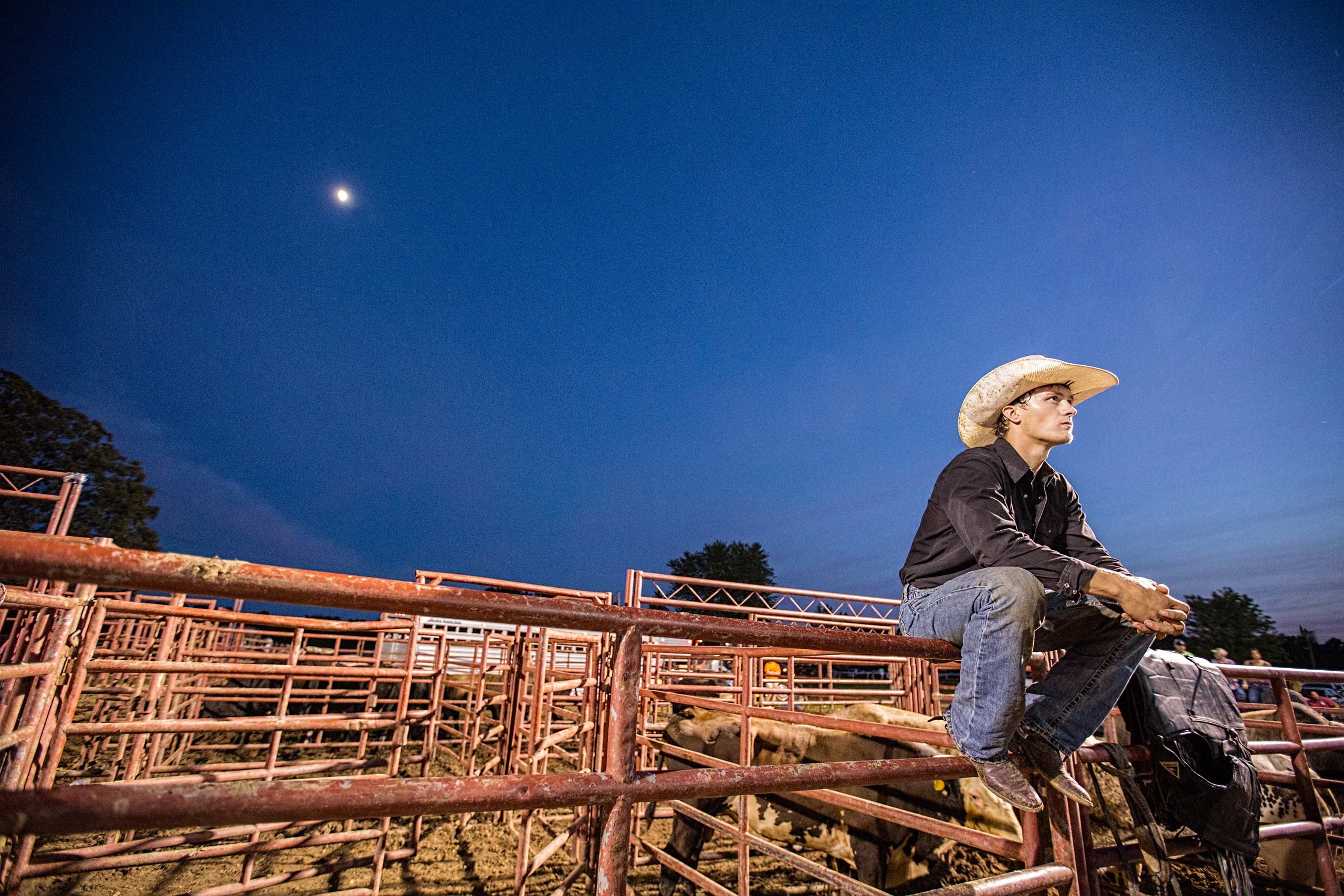 Cowboy Sitting On a Fence at Night Under the Moon