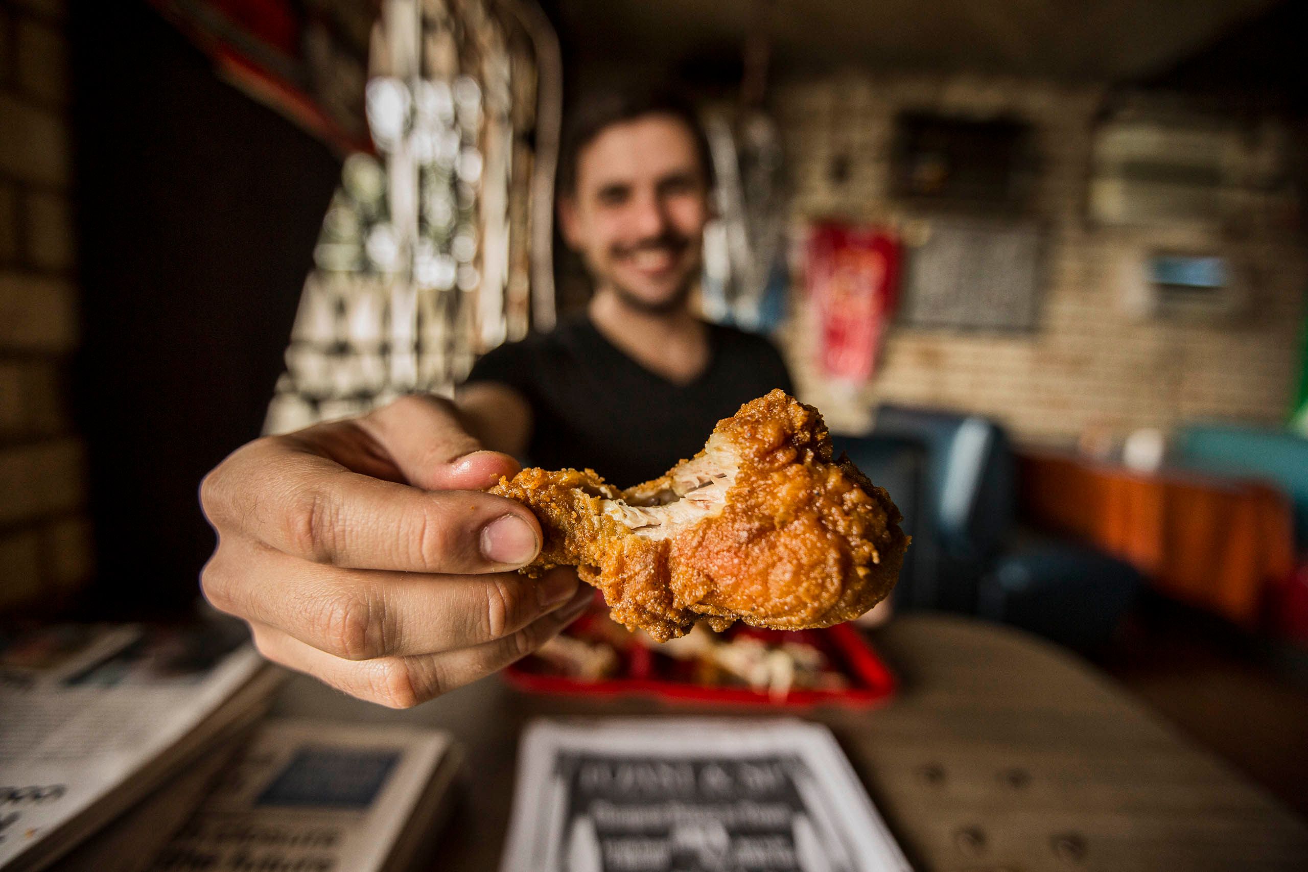 Man Holding Fried Chicken to the Camera
