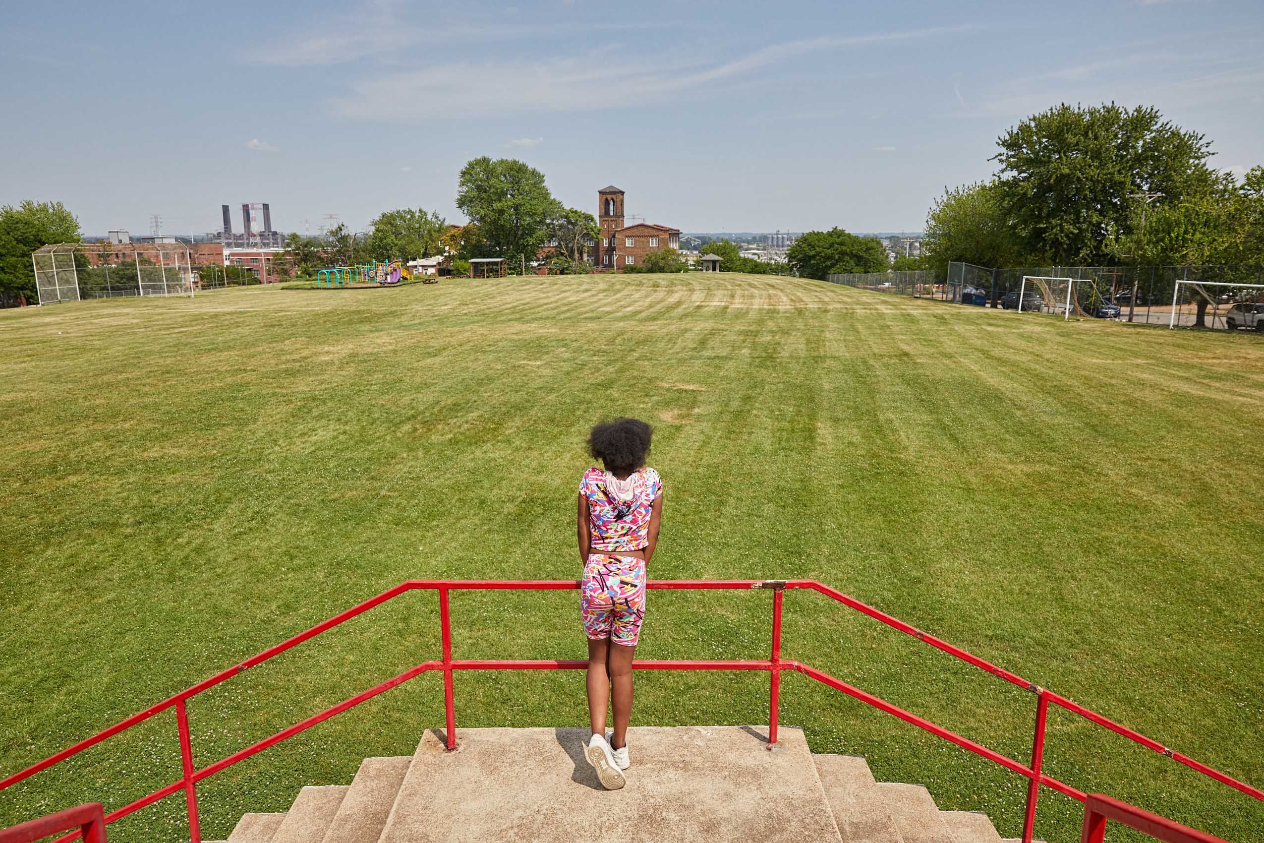 Girl Stares Out at Athletic Field