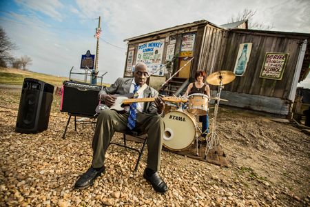 Leo "Bud" Welch playing guitar in front of Po Monkey's Juke Joint in Merigold, MS. Shot for the Mississippi Tourism campaign for advertising, branding, collateral and broadcast motion assets. Environmental portrait, and we are a industrial photographer, on location photographer & location commercial photographer. VisitMS Leo Bud Welch Playing Guitar