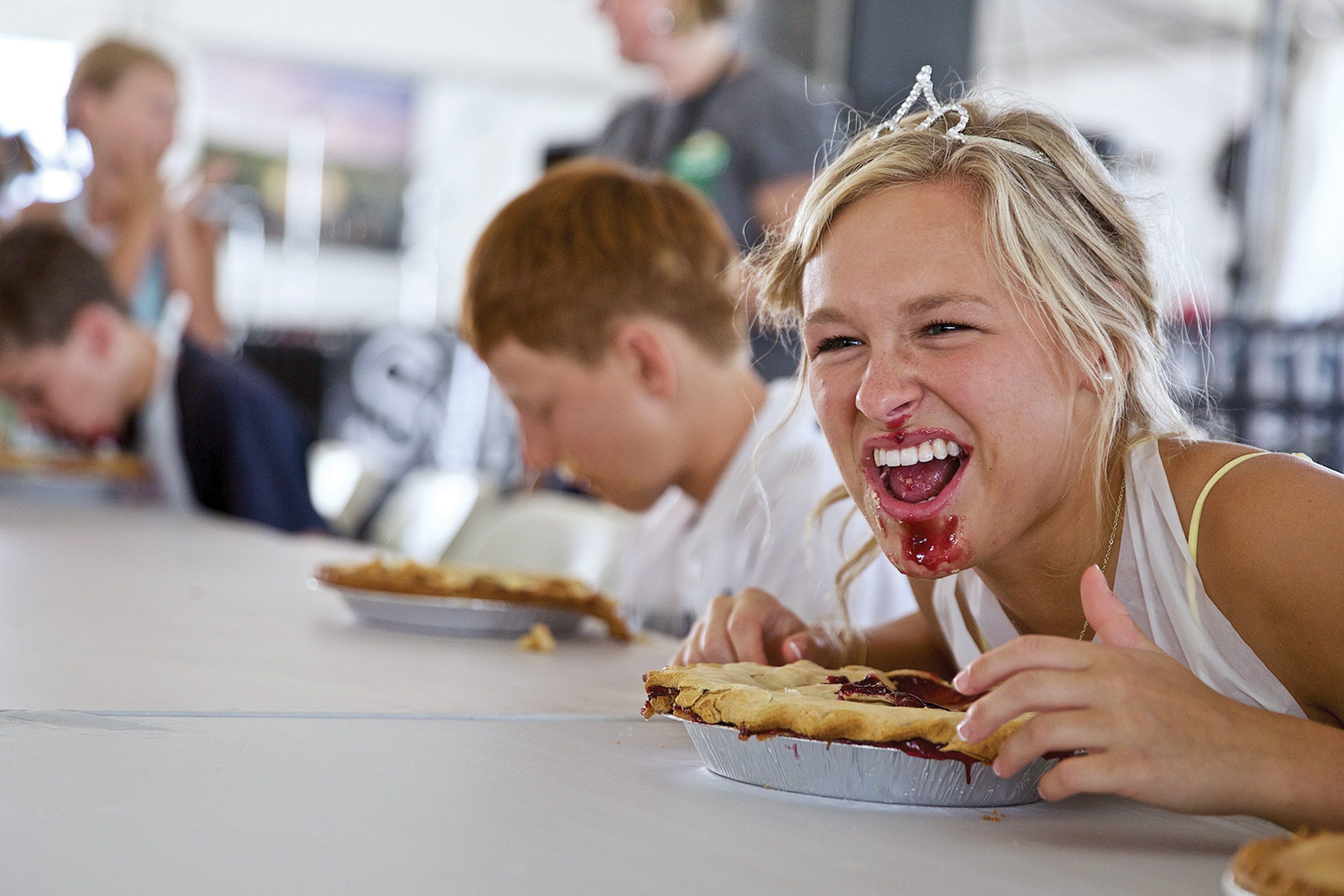 Girl With Crown Competing In a Pie Eating Contest