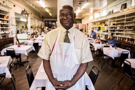 Portrait of Mr. D at his world famous restaurant fried chicken restaurant, The Old Country Store in Lorman, MS. He is looking off camera smiling. Shot for the Mississippi Tourism campaign for advertising, branding, collateral and broadcast motion assets. Environmental portrait, and we are a industrial photographer, on location photographer & location commercial photographer. Shallow depth of field and selective focus. VisitMS Mr. D at his The Old Country Store Known for Fried Chicken