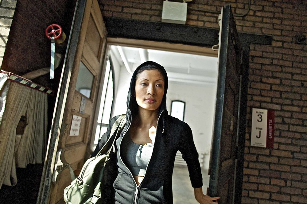 A woman walks into an urban gym dressed in Nike clothes ready for a workout. Woman Walks into Gym