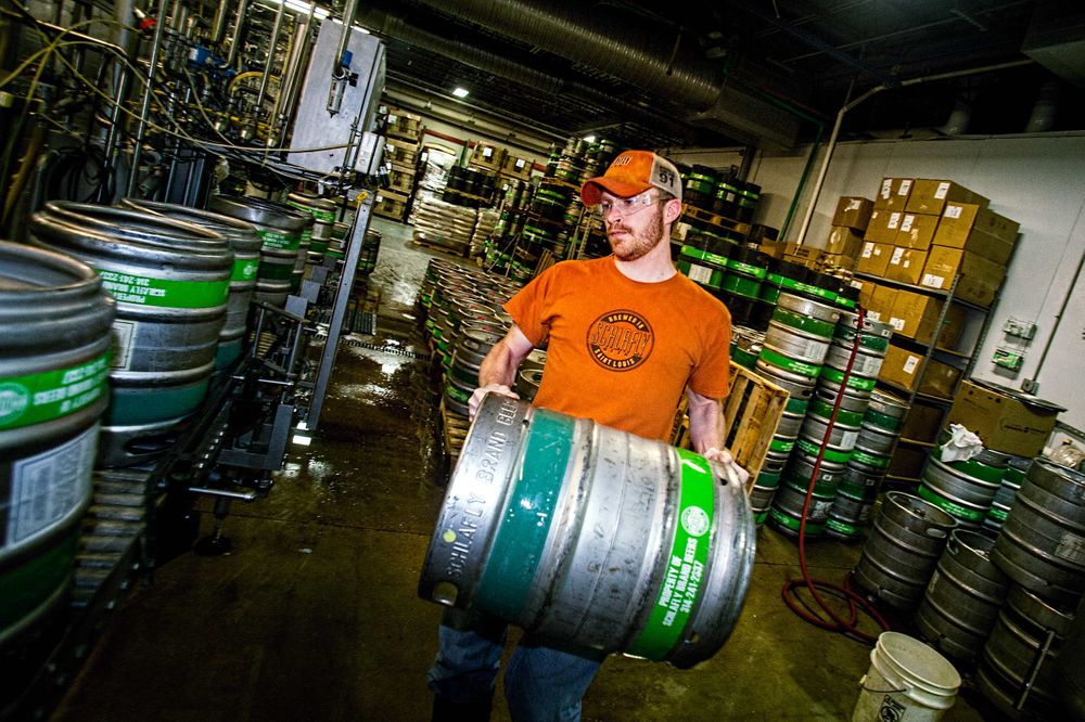 Photo at Schlafly Beer in St. Louis for an advertising campaign and image brand library of a man carrion a keg of beer, showing a little bit of a motion blur. Environmental portrait. As an industrial photographer, on location photographer & location commercial photographer this was a great project to be associated with. Man Loading a Keg