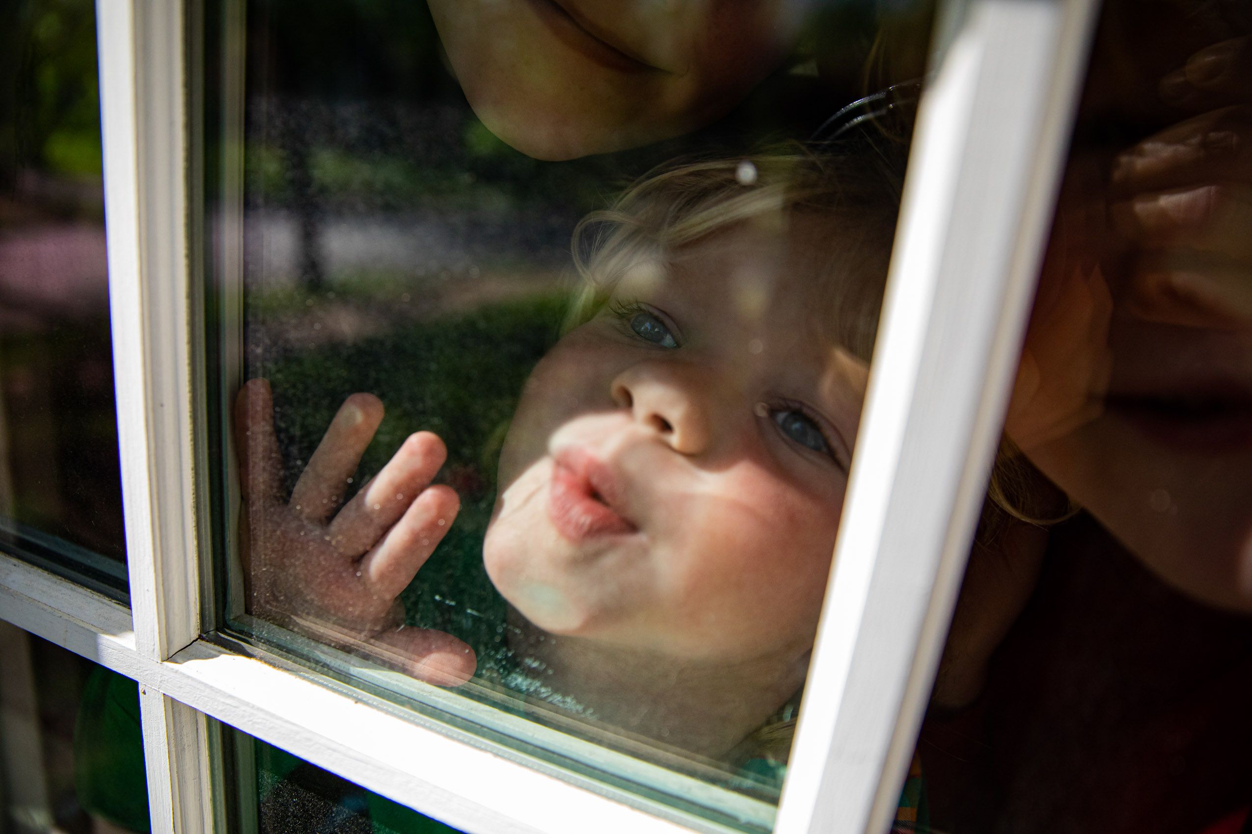 Child Blows Kiss Through Window