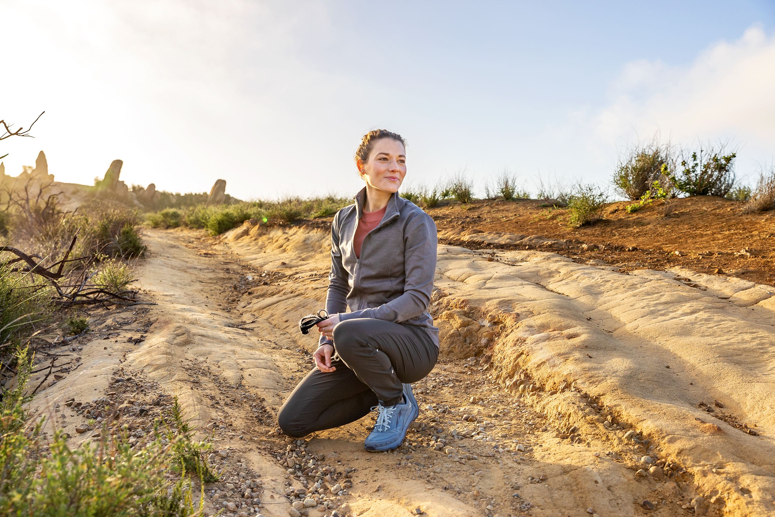 Woman Kneels on Desert Path