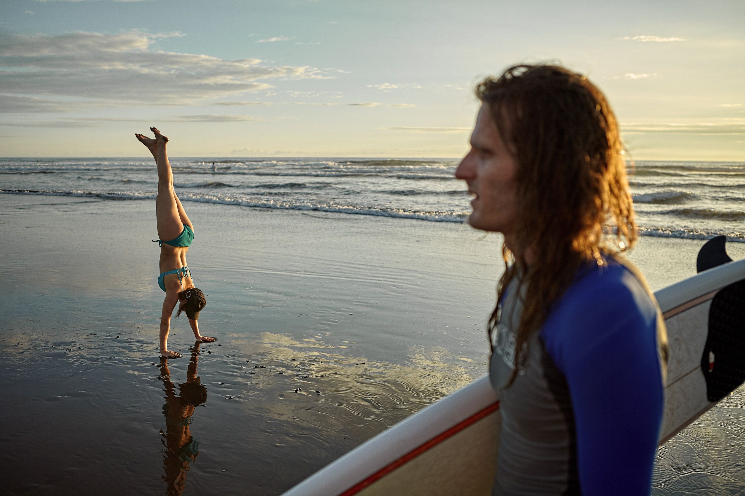Surfer Watches Beachgoer Do Handstand