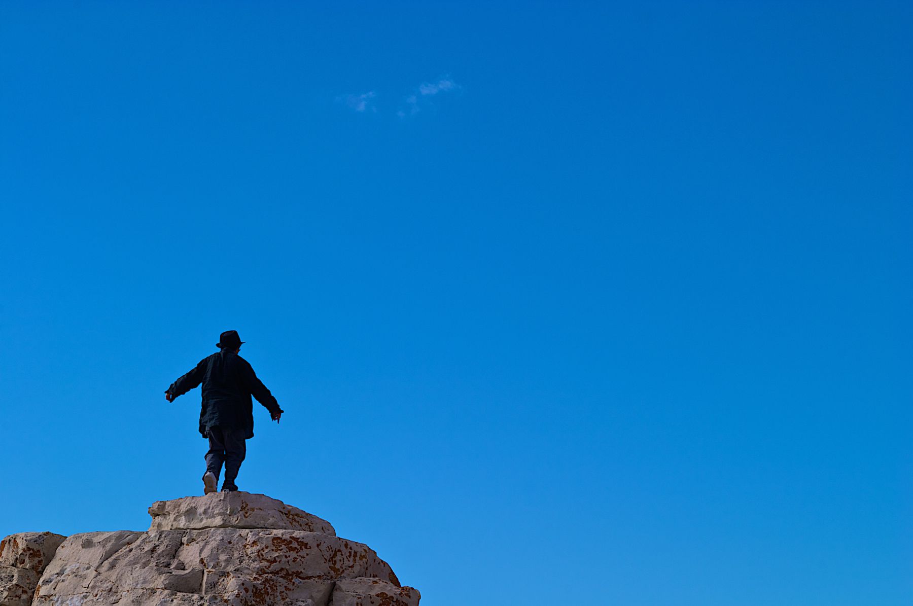 Man In a Suit On Top Of  a Cliff