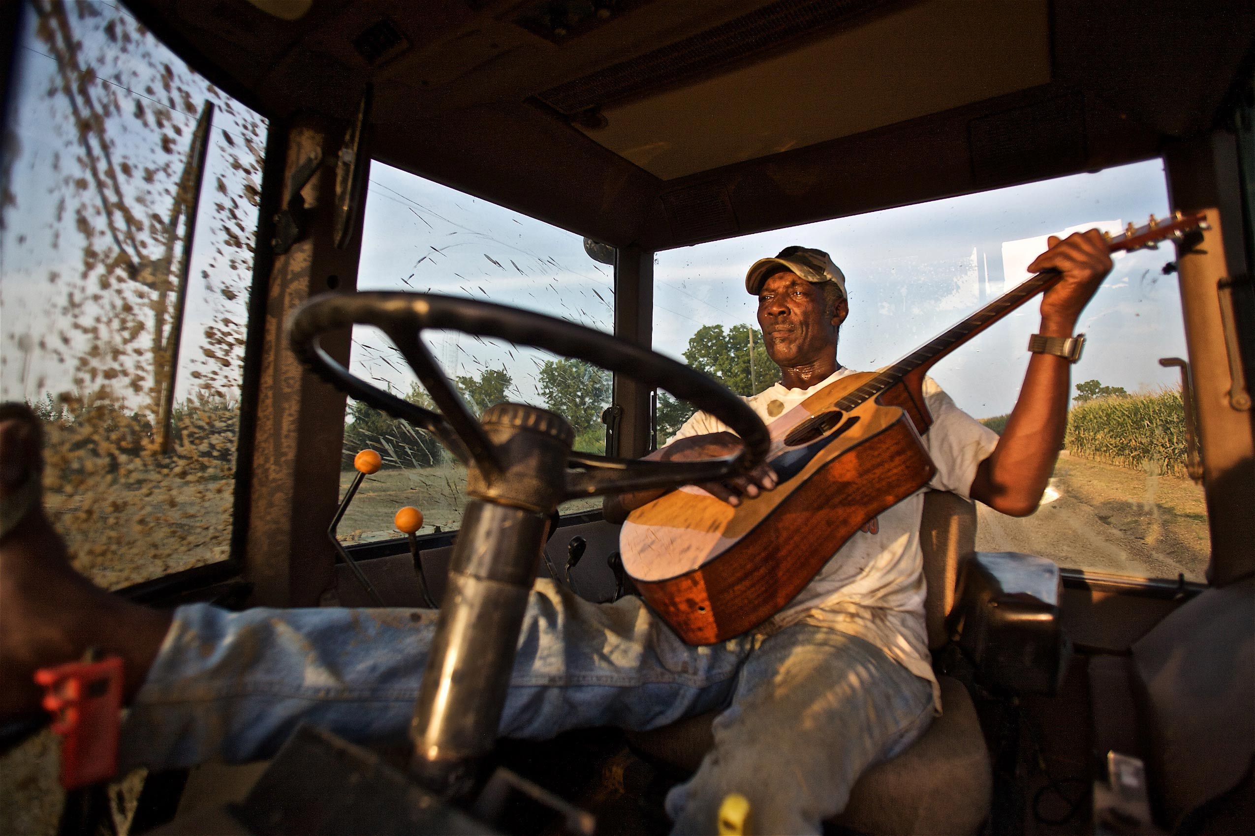 Rufas Roach Strumming Guitar In a Tractor