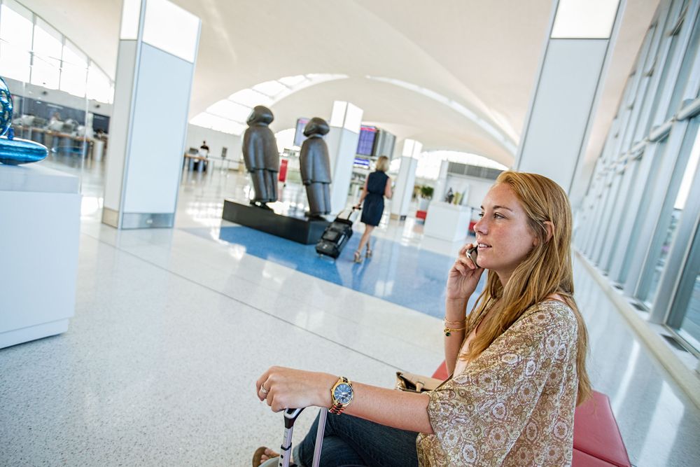 Passenger, moan in her 20's, on the telephone at STL St. Louis Lambert International Airport FLYSTL Environmental portrait, and we are a industrial photographer, on location photographer & location commercial photographer. Shallow depth of field and selective focus. FLYSTL Passenger at STL St. Louis Lambert International Airport FLYSTL