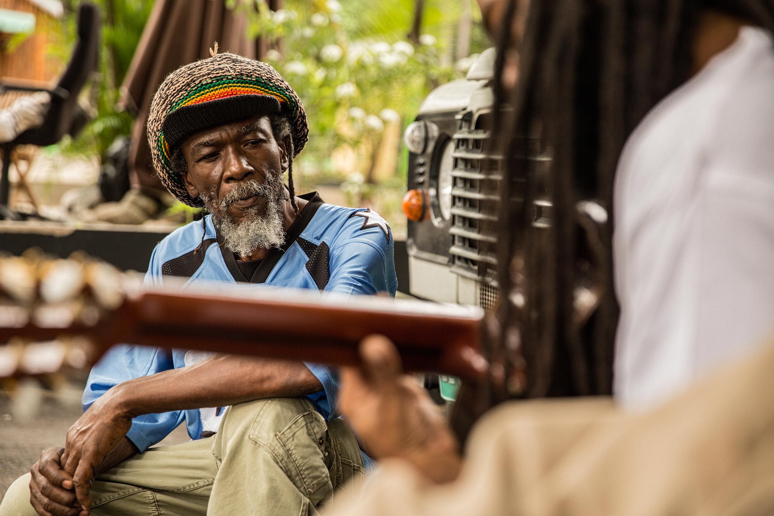 Rastafari Man Listening to a Man Playing Guitar