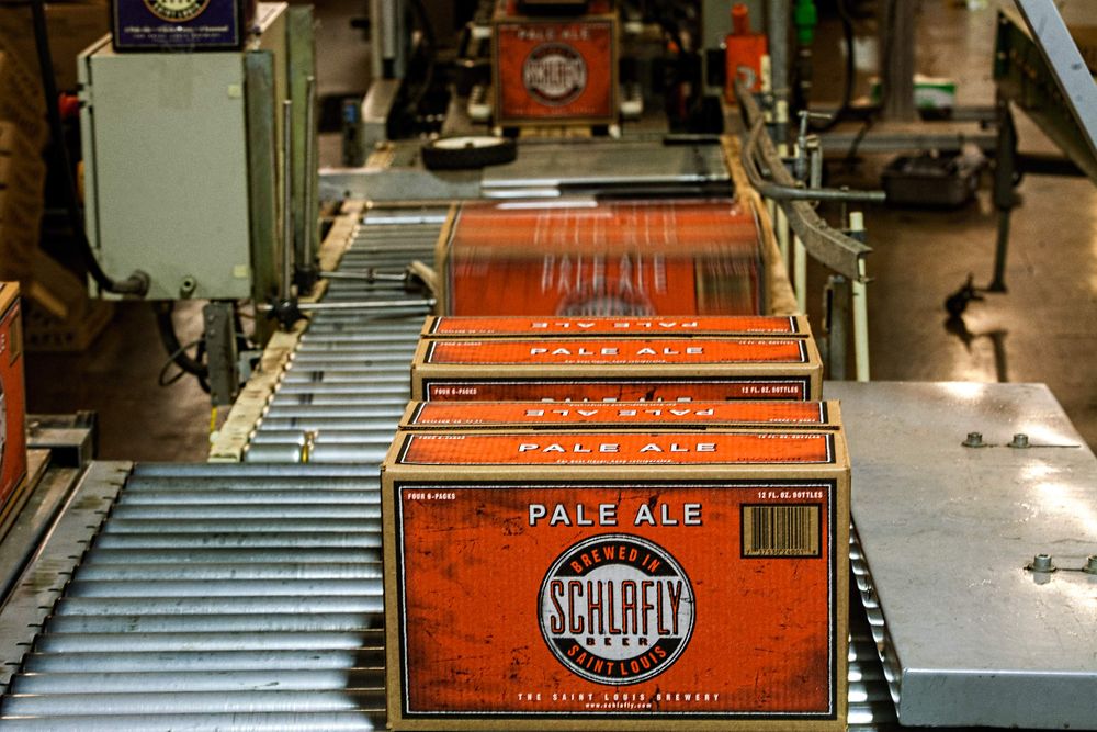 Photo at Schlafly Beer in St. Louis for an advertising campaign and image brand library. Cases of Pale Ale beer cases coming off of a conveyor belt production line, motion blur. Environmental portrait. As an industrial photographer, on location photographer & location commercial photographer this was a great project to be associated with. Cases of Beer Coming Off of a Production Line