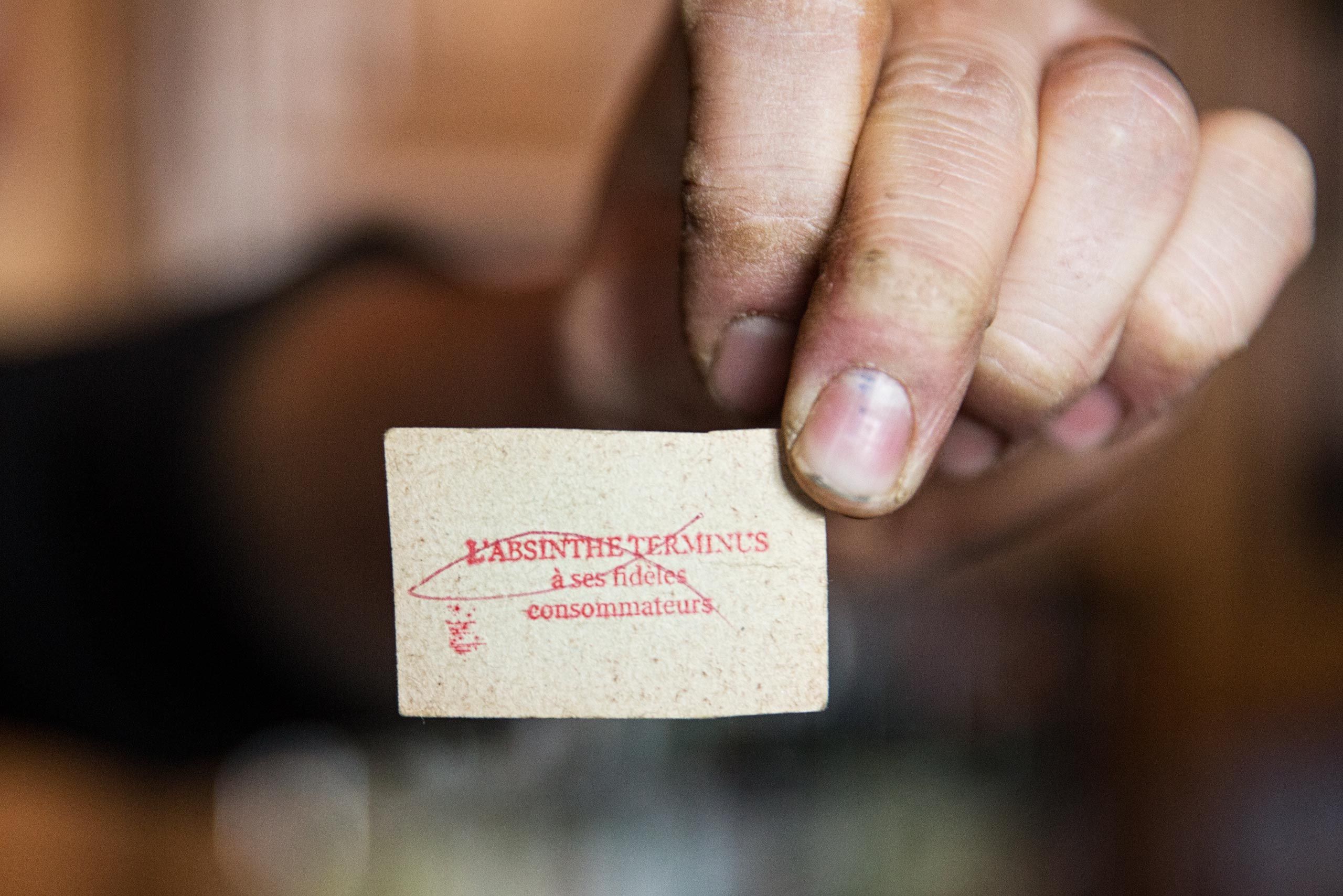 Man Holding an Old Card Relating to Absinthe
