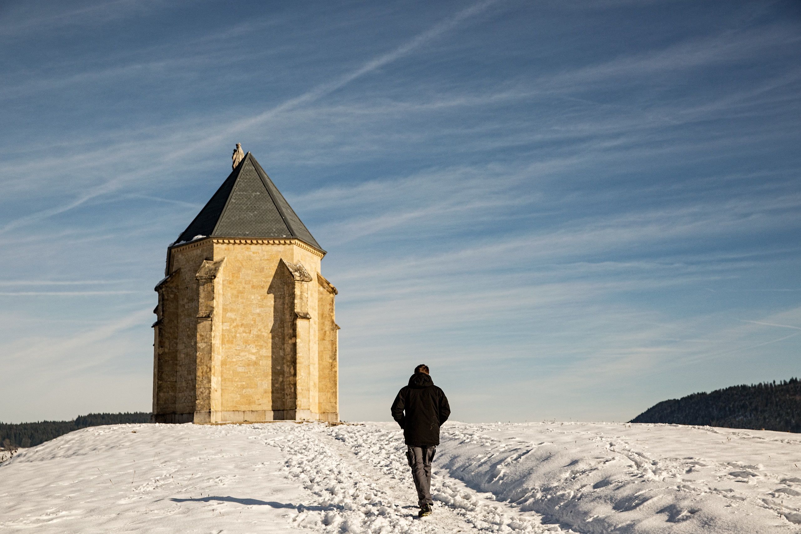 Man Walking In Snow To a Tiny Church