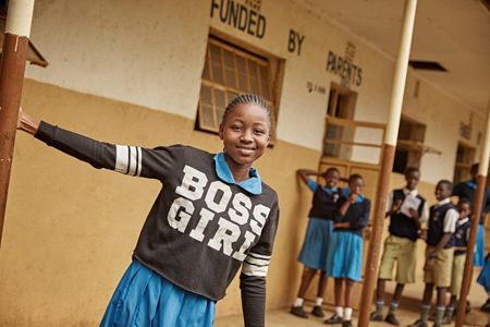 A girl wearing a Boss Girl sweater hanging out and smiling at school. Girl at a Secondary Girl
