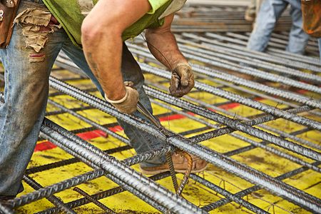 A man from a local union installing rebar to the floor of SolarCity, a large solar manufacturing facility in Buffalo, NY. Man Installing Rebar