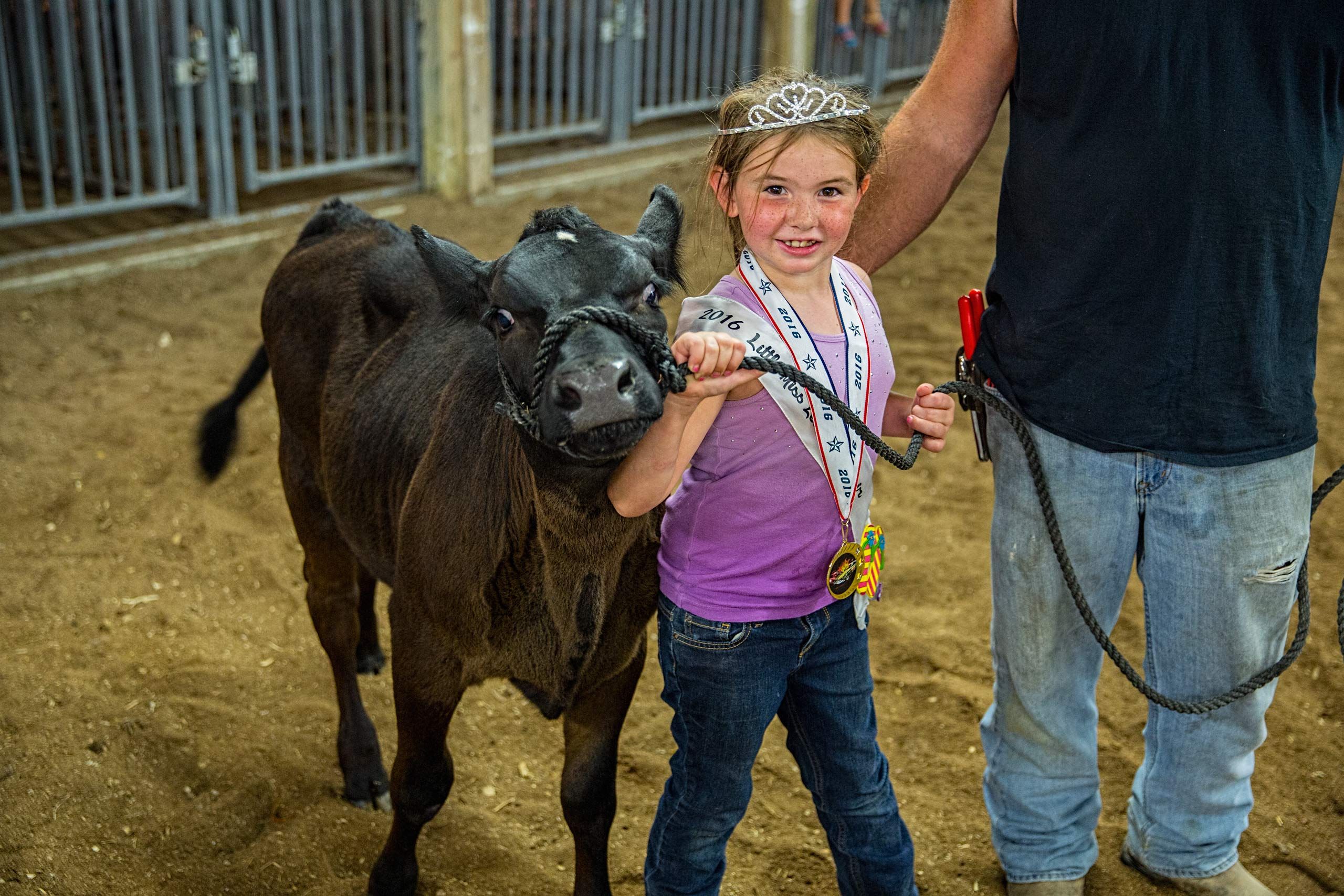 A young Girl Exhibiting Her Cow