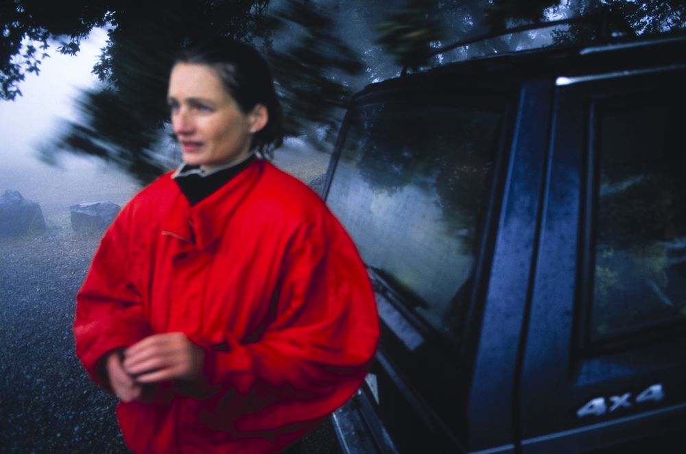 In the rain on Mount Tamalpais during a funeral for Stevie who succumbed to Aids. Marin County, California. Red jacket at a funeral.