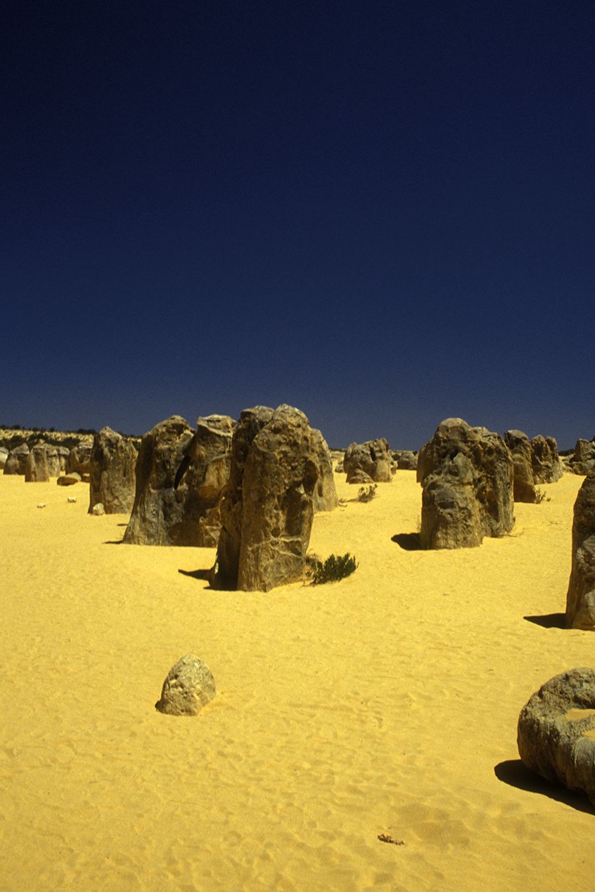 Vertical rocks and yellow sand.