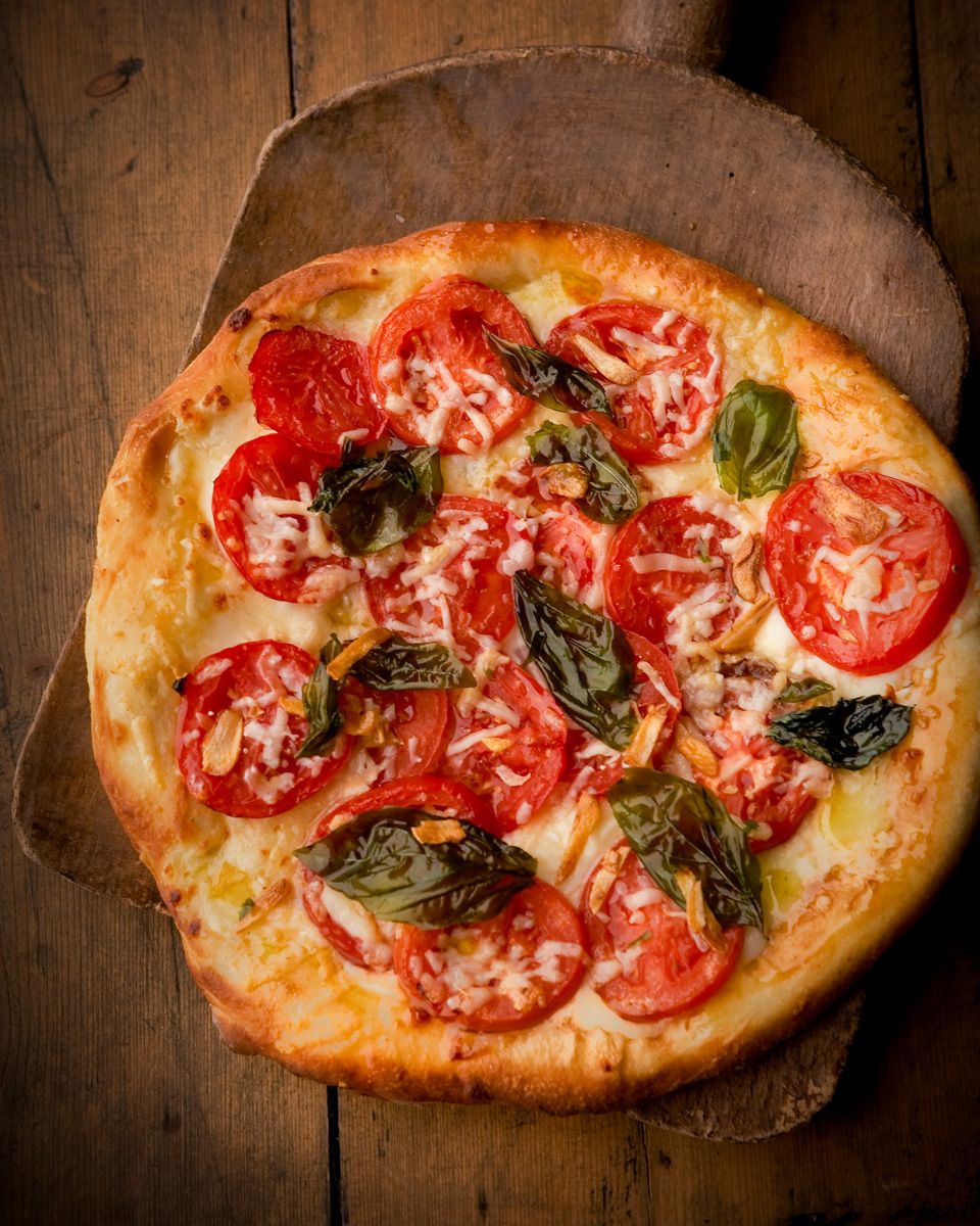 Giada De Laurentiis Margherita pizz with tomatoes and basil on rustic wooden board www.rkjacobs.comRobert Jacobs Photography ©2013 Top Food Photographer New York Seattle Portland