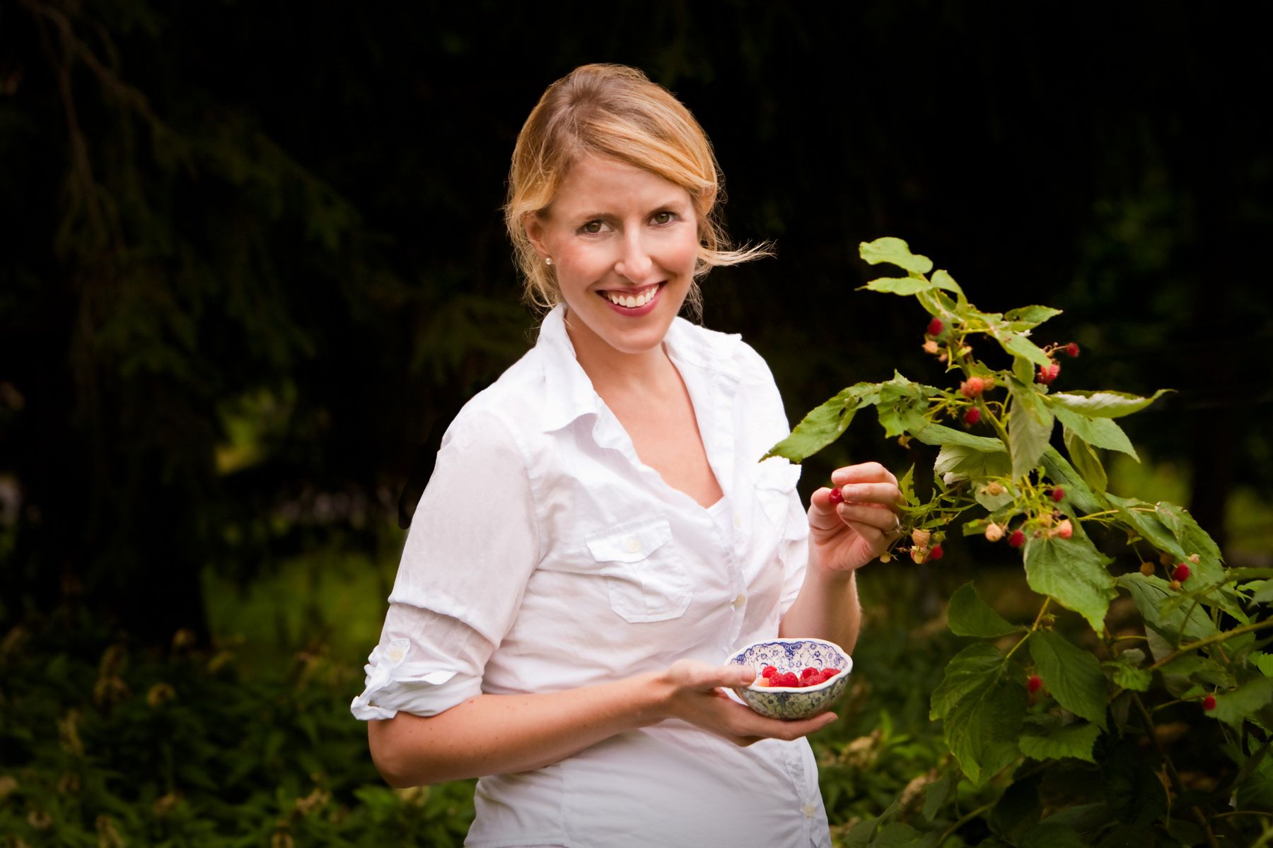 Pregnant young  blond woman picking red raspberries in garden www.rkjacobs.comTop Food Photographer New York Seattle PortlandRobert Jacobs Photography ©2013 Pregnant young  blond woman picking red raspberries in garden www.rkjacobs.comTop Food Photographer New York Seattle PortlandRobert Jacobs Photography ©2013