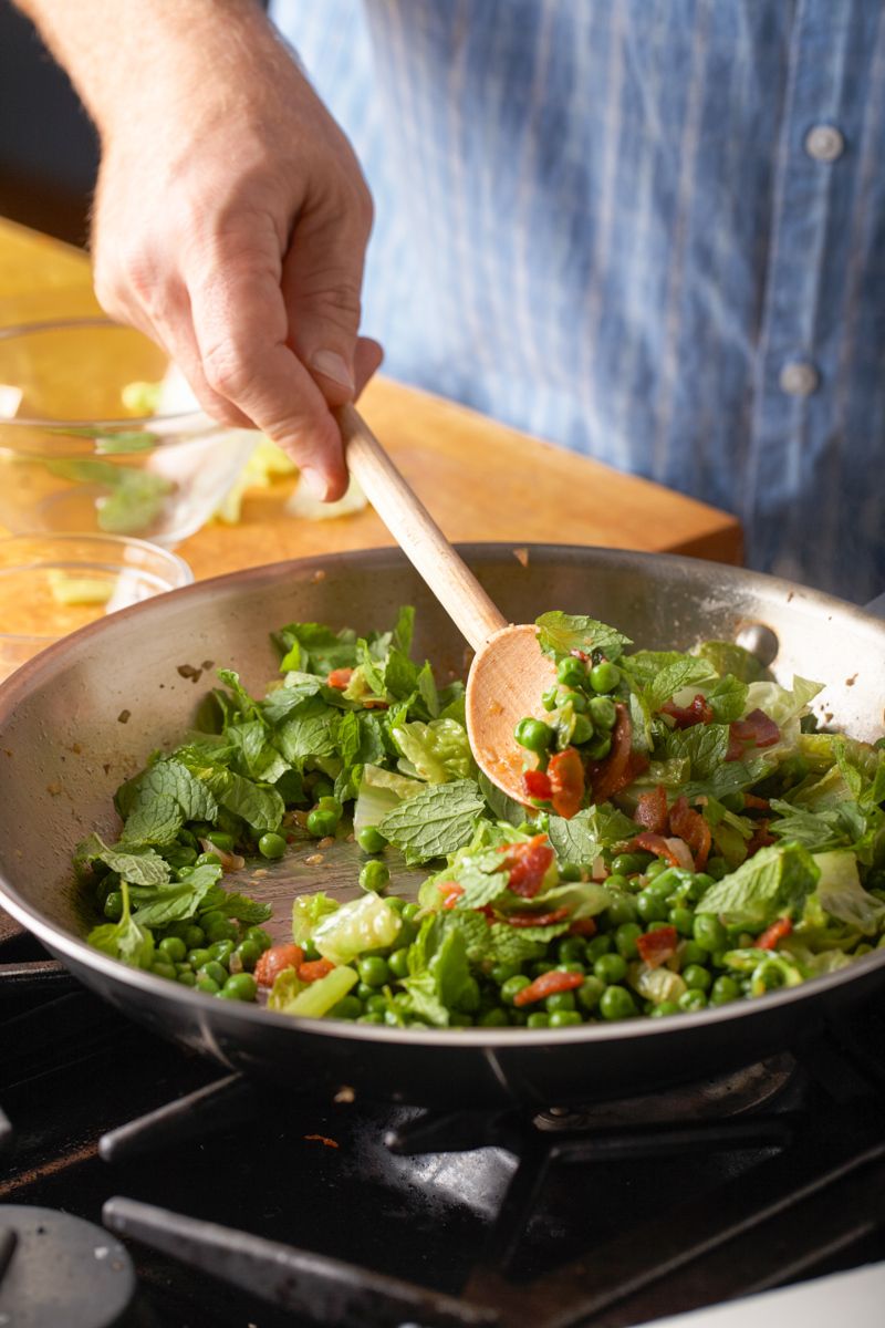 Man stirring at range top pan of peas, mint and bacon for Mark Bittman app. "How to Cook Everything" New York Timeswww.rkjacobs.comTop Food Photographer New York Seattle PortlandRobert Jacobs Photography ©2013 Man stirring at range top pan of peas, mint and bacon for Mark Bittman app. "How to Cook Everything" New York Timeswww.rkjacobs.comTop Food Photographer New York Seattle PortlandRobert Jacobs Photography ©2013