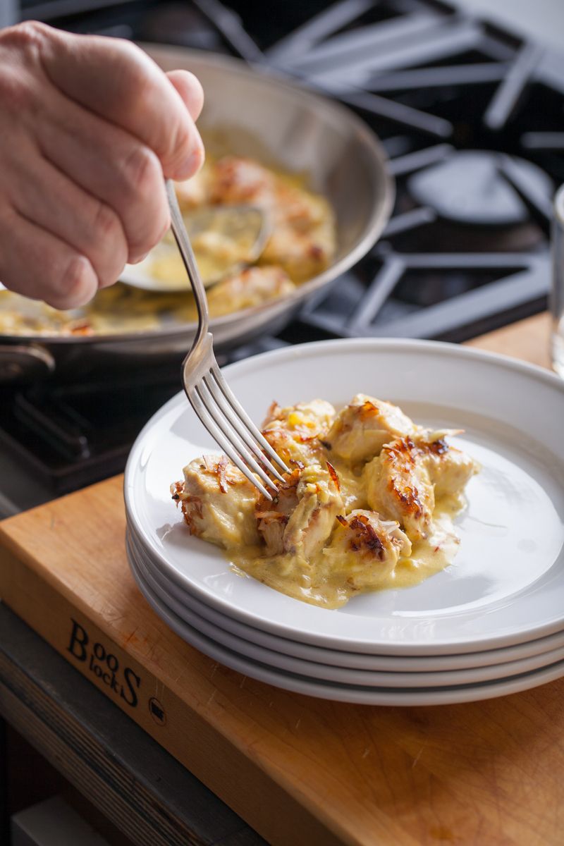 Hand holding fork with curry chicken in kitchen with gas rangewww.rkjacobs.comRobert Jacobs Photography ©2013 Top Food Photographer New York Seattle Portland www.rkjacobs.comRobert Jacobs Photography ©2013 Top Food Photographer New York Seattle Portland