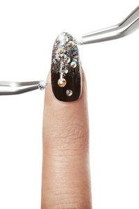 Fashion Nails holding manicure tools. Glitter Nail art  and luxury manicures.