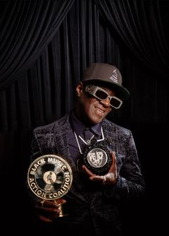 Photo of BMAC Gala Beverly Hills, Flavor Flave, Public Enemy, Honoree, with trophy against black velvet curtain