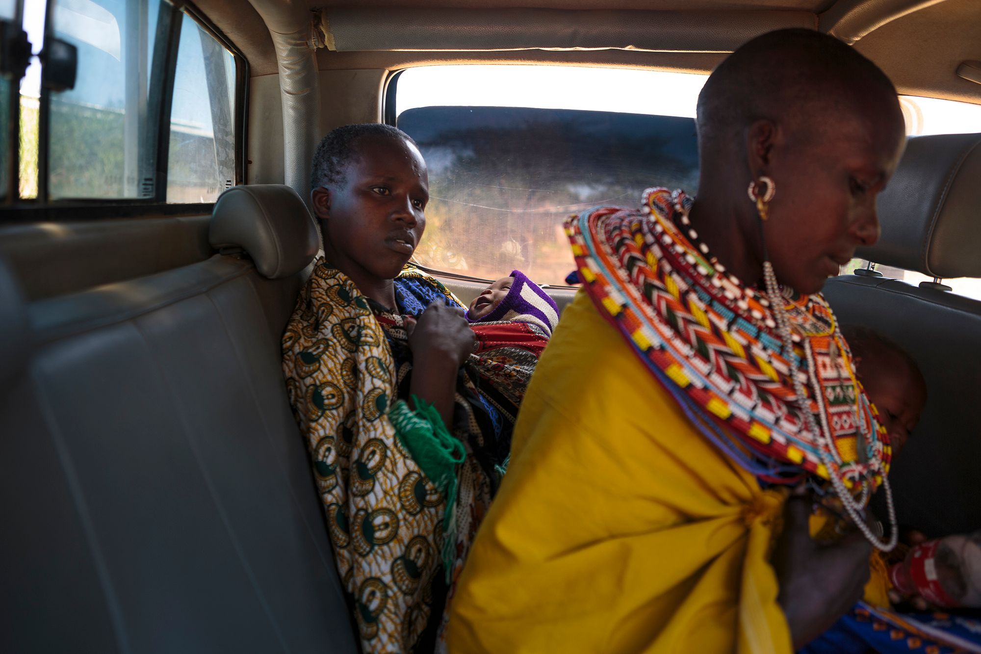 Two young mothers hold their babies in the back of the Samburu Girls Foundation’s truck after the organisation negotiated with village leaders care for them at their safe house. The young women had run away after their babies were threatened with death. Younger girls who have not undergone FGM are often “beaded,” which acts as a temporary engagement, allowing Morans, or warriors, to have sex with her. If the girls get pregnant, the community demands that the child is killed. 16.jpg