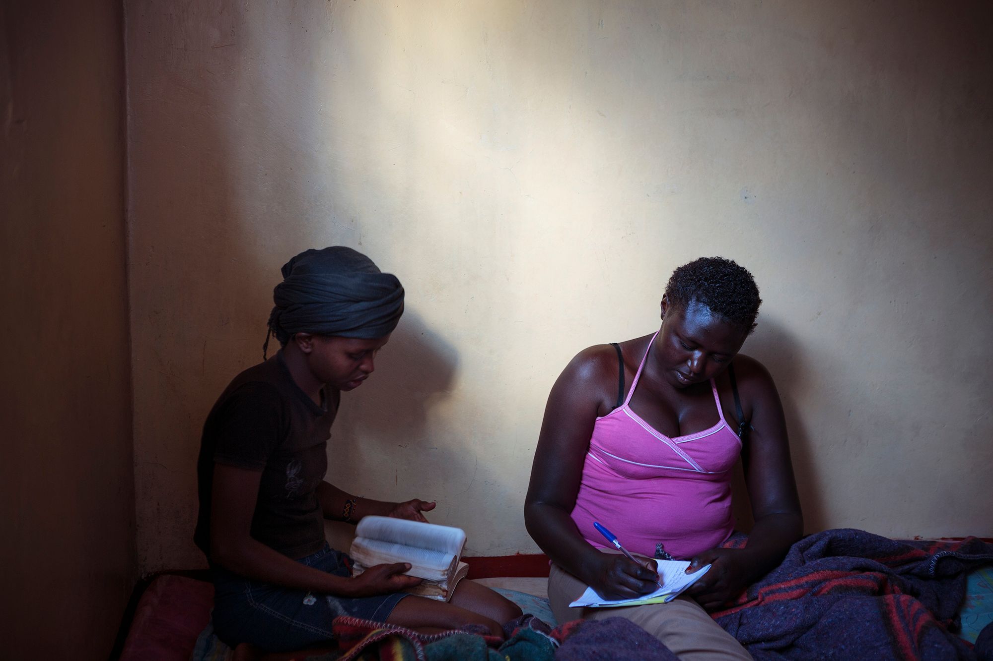 Jane writes a letter with the help of Sylvia, 19, who helps run the safe house. 08.jpg