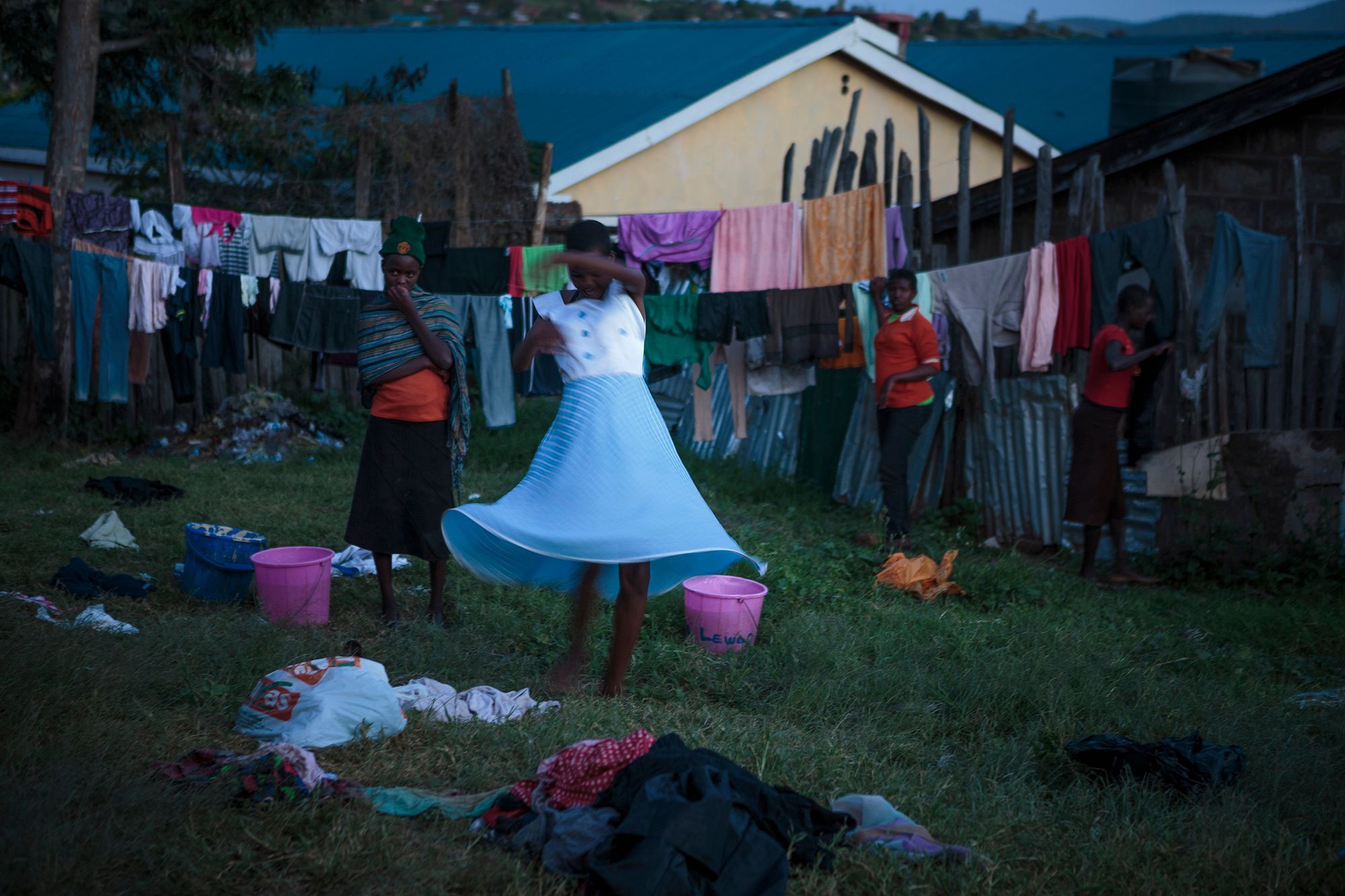 A young girl twirls in a carefree moment during laundry day at the safe house. 09.jpg