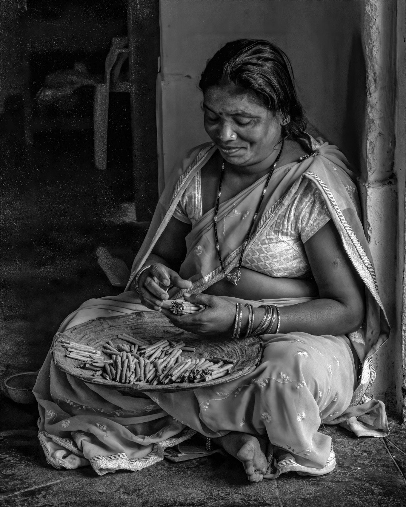 Woman gathering beedies into stacks, to be delivered to a middleman for eventual sale at  markets and fairs (Village in Chhattisgarh) work.laborers-30.jpg