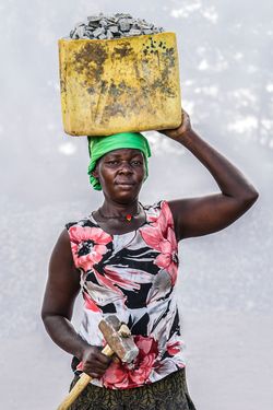Jennider Abu (age 40) working in quarry for 9 years breaking stones to create gravel. Earns 1,000 shillings ($0.32 USD) per Jerrycan of gravel. Earns 10,000 to 13,000 shillings per day.
