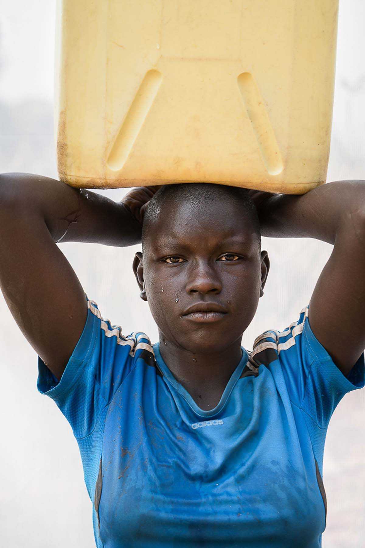 Sahra carrying 5 gal jerrycan of water