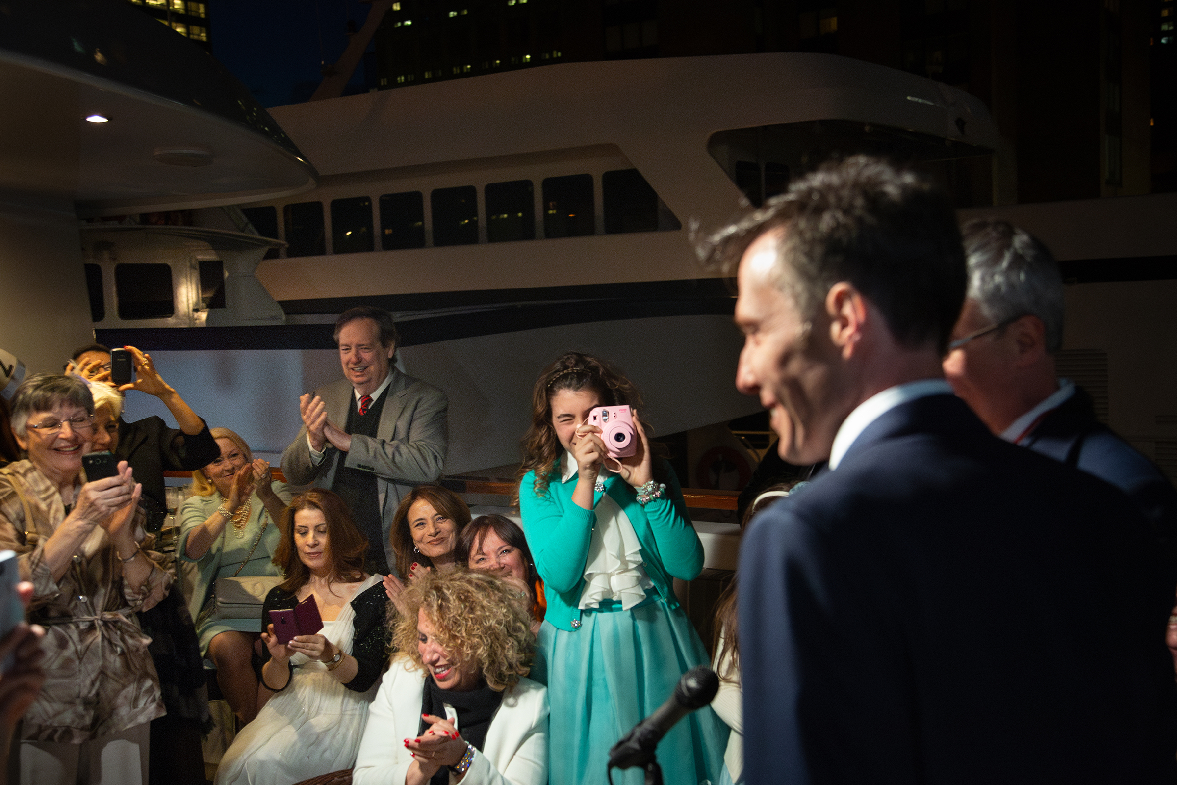 Teen girl taking Polaroid photo at yacht wedding