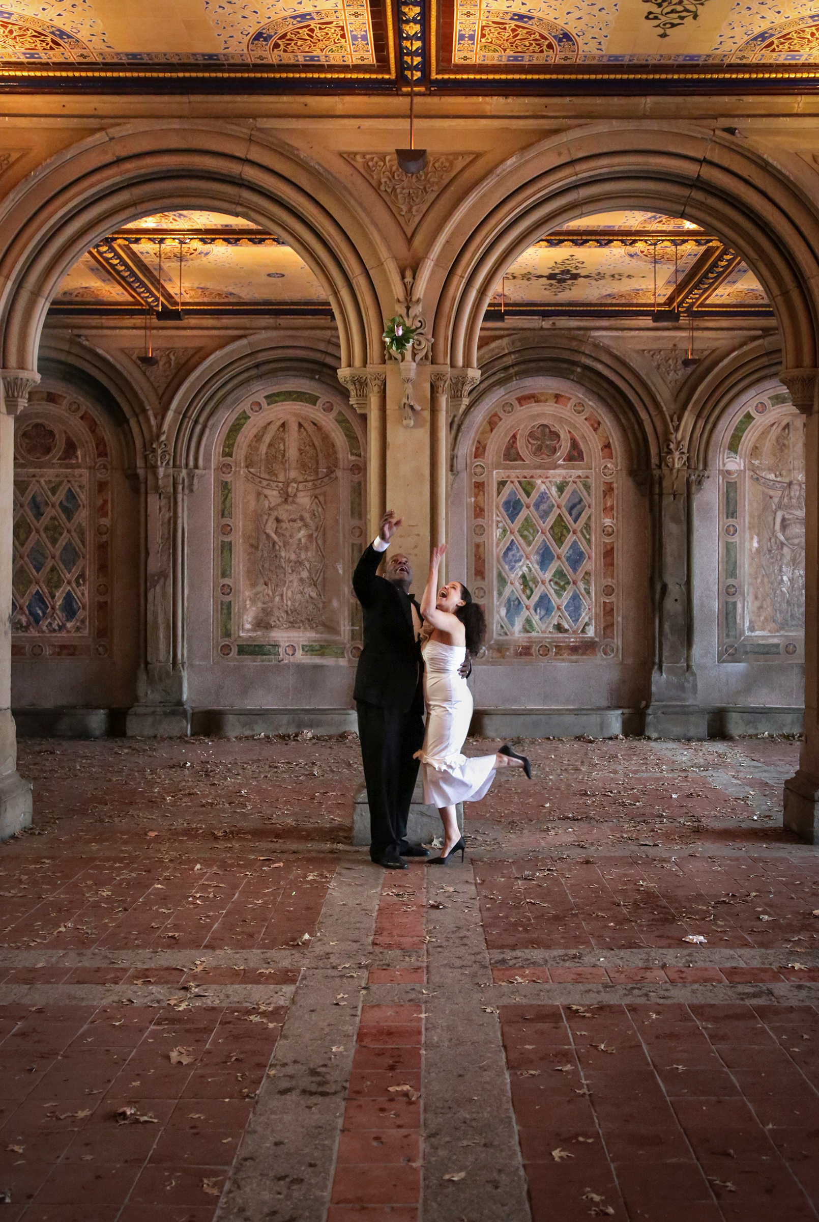 Bride tossing bouquet inside Bethesda Terrace Arcade
