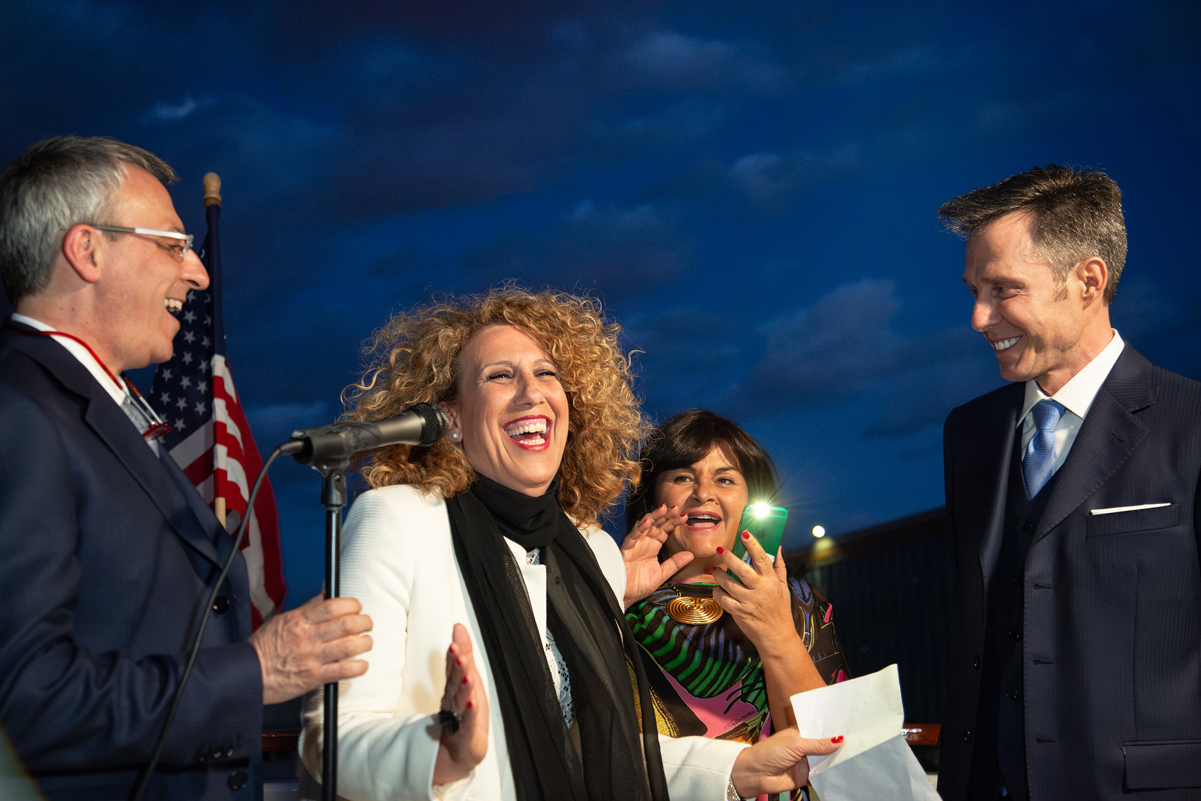 Grooms laughing with guest speaker during yacht weddingc