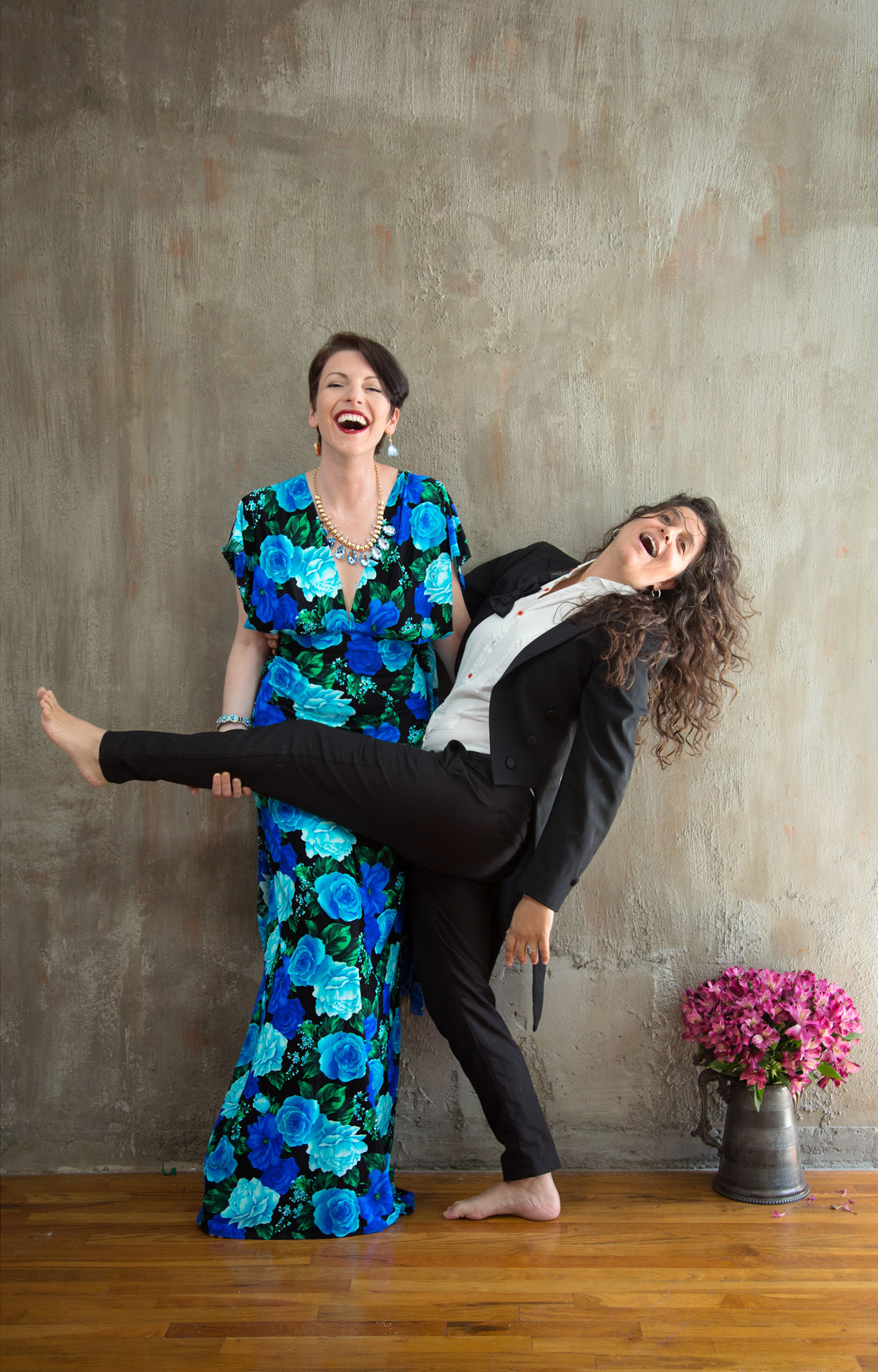 Lola lifting her leg as Anna holds it in campy pre‑wedding portrait