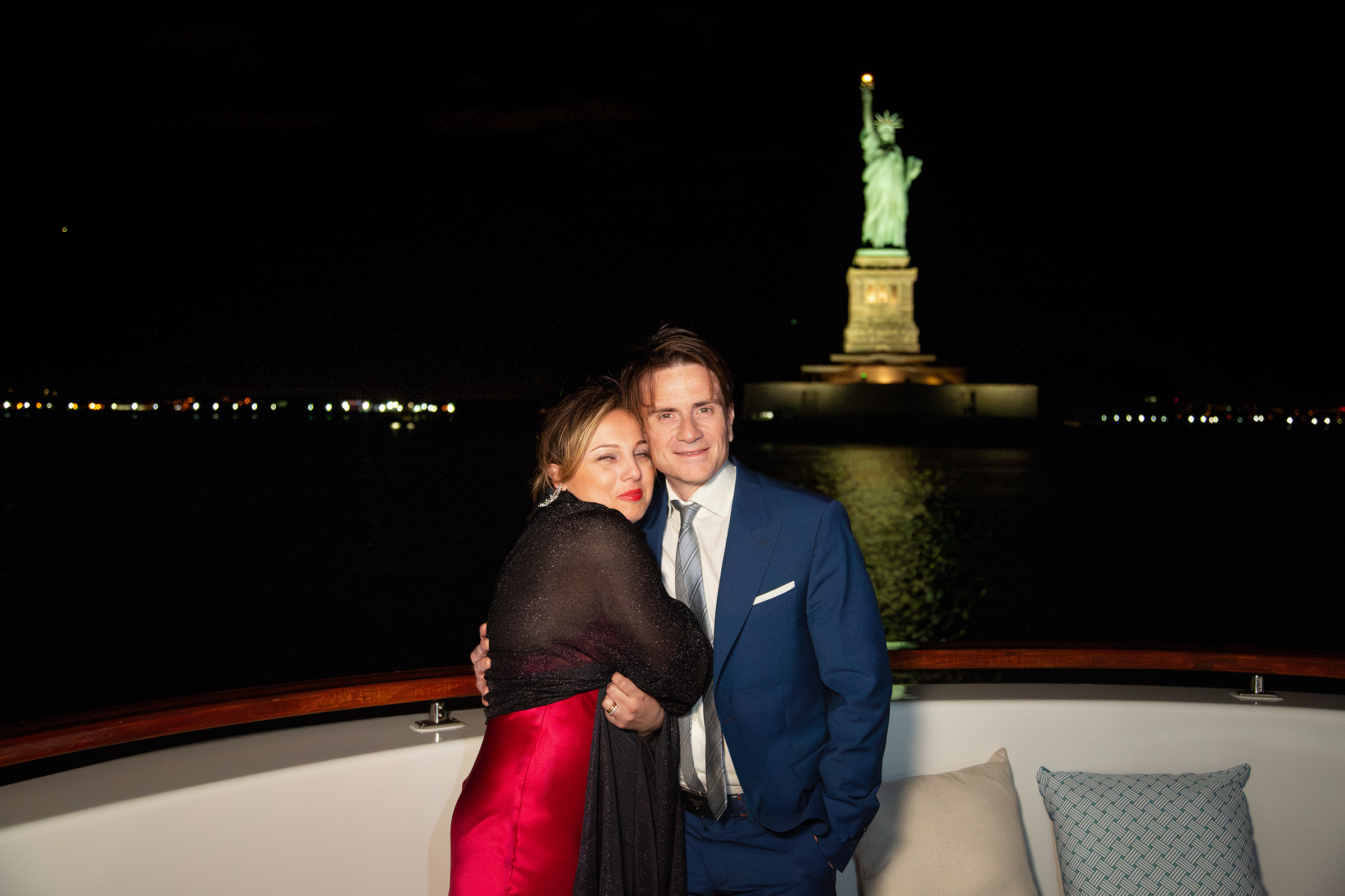 talian couple embracing aboard yacht near Empire State Building