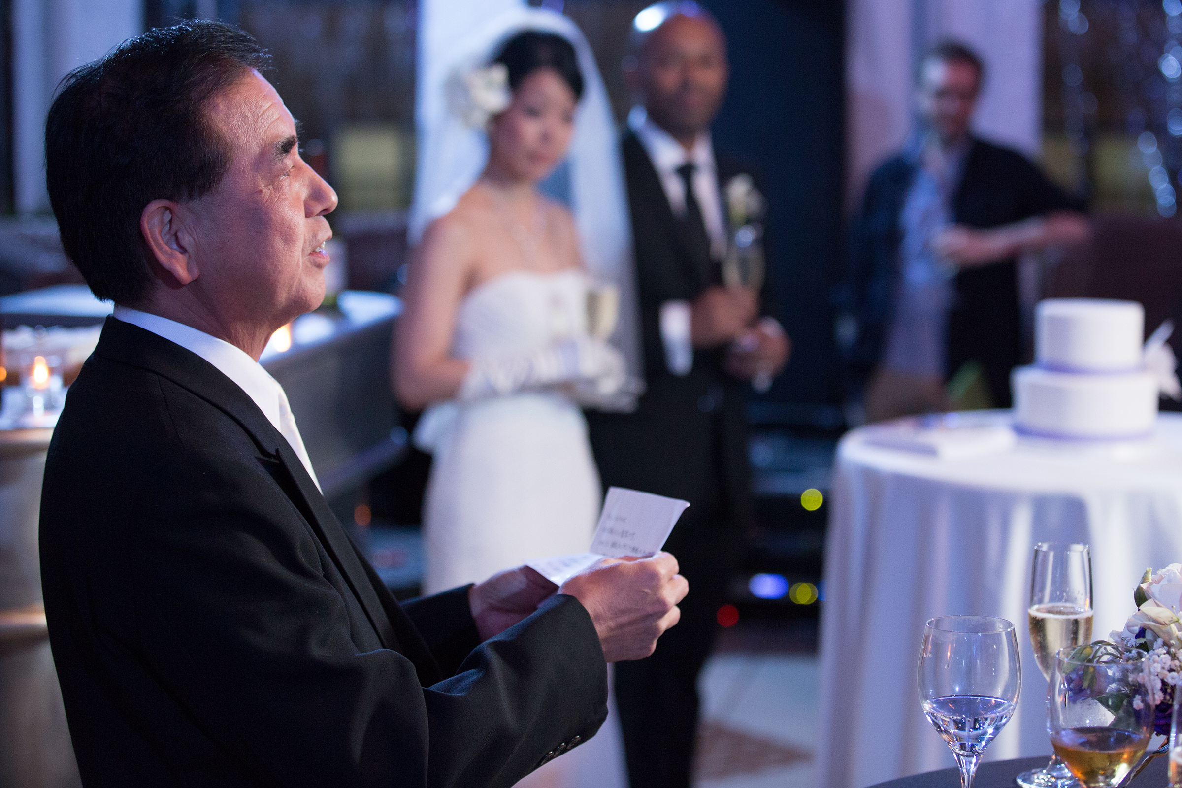 Father of bride giving speech in violet wedding lighting